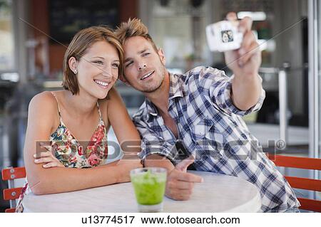 Stock Photo - Couple taking pictures of themselves. Fotosearch