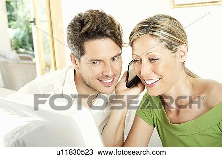 Couple talking on cell phone together View Large Photo Image Stock Image - Couple talking on cell phone together. Fotosearch