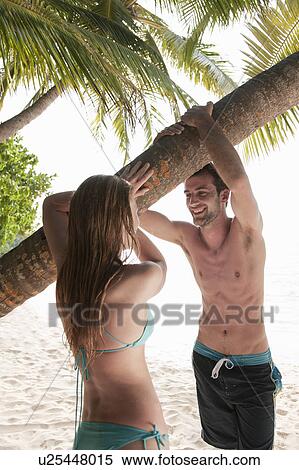 Couple talking under palm tree on beach View Large Photo Image Stock Photography - Couple talking under palm tree on beach. Fotosearch