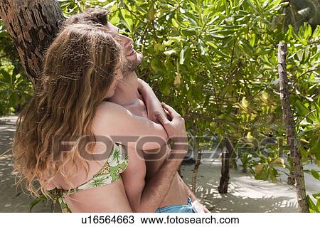Couple talking under tree on beach View Large Photo Image Stock Image - Couple talking under tree on beach. Fotosearch