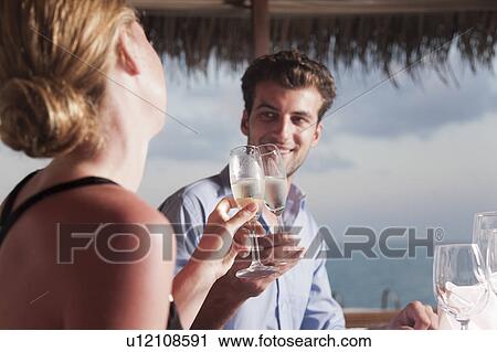 Couple toasting each other at dinner View Large Photo Image Stock Image - Couple toasting each other at dinner. Fotosearch