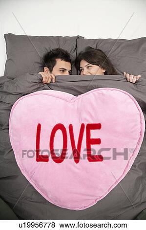 Couple under blanket reading ’love’ View Large Photo Image Stock Photo - Couple under blanket reading ’love’. Fotosearch