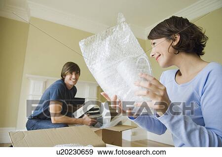 Couple unpacking boxes in new home View Large Photo Image Stock Photo - Couple unpacking boxes in new home. Fotosearch