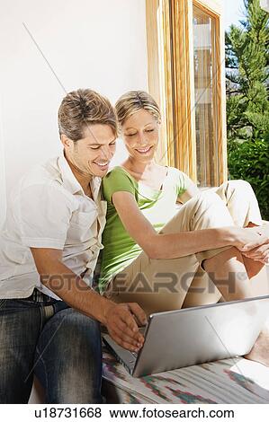 Stock Photo - Couple using laptop together. Fotosearch