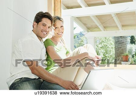 Couple using laptop together View Large Photo Image Stock Photo - Couple using laptop together. Fotosearch