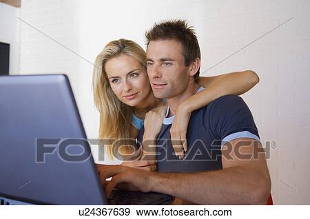 Stock Photo - Couple using laptop together. Fotosearch