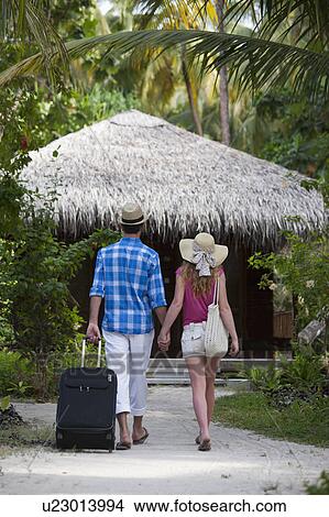 Couple walking hand-in-hand at resort View Large Photo Image Picture - Couple walking hand-in-hand at resort. Fotosearch