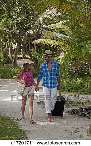 Couple walking hand-in-hand at resort View Large Photo Image Stock Image - Couple walking hand-in-hand at resort. Fotosearch