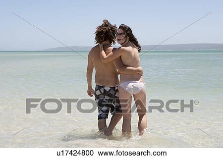 Couple walking in water at beach View Large Photo Image Stock Image - Couple walking in water at beach. Fotosearch