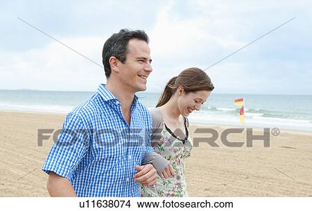 Picture - Couple walking on beach. Fotosearch