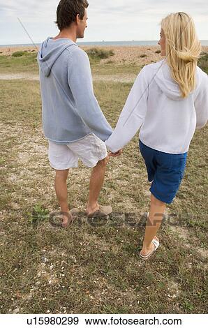 Couple walking on near ocean View Large Photo Image Stock Photo - Couple walking on near ocean. Fotosearch