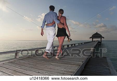 Stock Photograph - Couple walking together on dock. Fotosearch