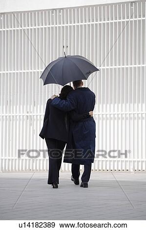 Couple walking under umbrella View Large Photo Image Stock Photo - Couple walking under umbrella. Fotosearch