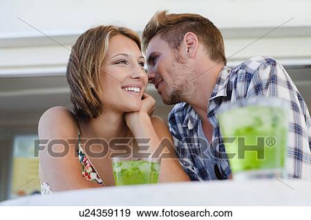 Couple whispering together at cafe View Large Photo Image Stock Photo - Couple whispering together at cafe. Fotosearch