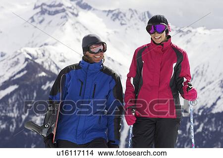 Picture - Couple with ski poles on mountain. Fotosearch