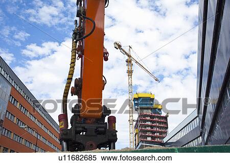 Stock Photography - Crane at construction site in city. Fotosearch