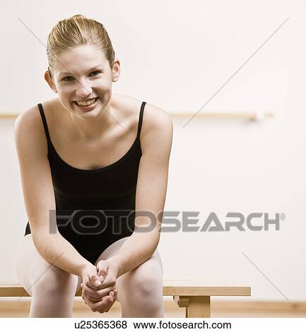 Stock Photo - Dancer sitting on bench in studio. Fotosearch