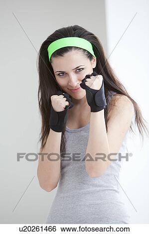Stock Photograph - Defensive woman wearing boxing gloves. Fotosearch