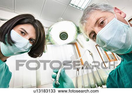 Dentist and assistant working in office View Large Photo Image Stock Image - Dentist and assistant working in office. Fotosearch