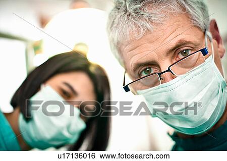 Dentist and assistant working in office View Large Photo Image Stock Photograph - Dentist and assistant working in office. Fotosearch