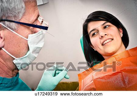 Stock Photo - Dentist and patient talking in office. Fotosearch