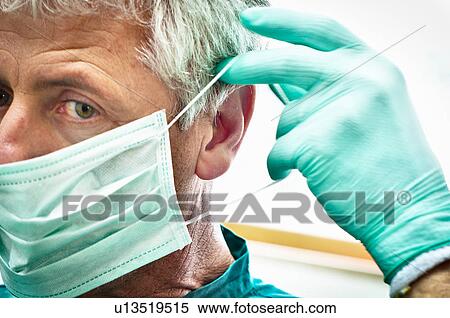 Dentist putting on face mask View Large Photo Image Stock Photography - Dentist putting on face mask. Fotosearch