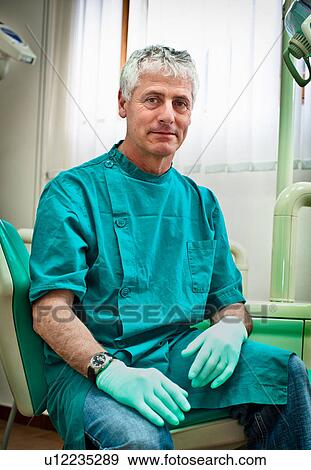 Stock Photo - Dentist sitting in office. Fotosearch