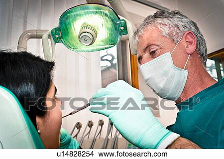 Dentist working on patient in office View Large Photo Image Picture - Dentist working on patient in office. Fotosearch