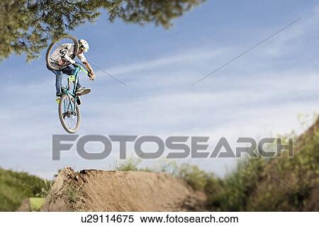 Dirt biker doing tricks during jump View Large Photo Image Stock Photography - Dirt biker doing tricks during jump. Fotosearch