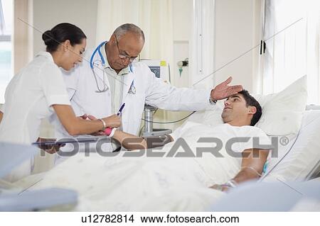 Doctor and nurse with hospital patient View Large Photo Image Picture - Doctor and nurse with hospital patient. Fotosearch