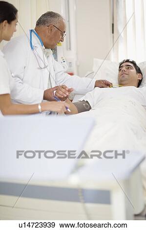 Stock Photo - Doctor and nurse with hospital patient. Fotosearch