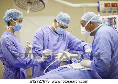 Doctor and nurses performing operation View Large Photo Image Stock Image - Doctor and nurses performing operation. Fotosearch