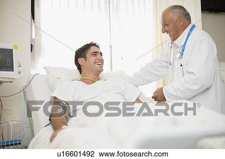 Stock Image - Doctor tending to hospital patient. Fotosearch