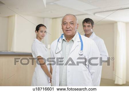 Stock Image - Doctors and nurse standing in hospital. Fotosearch