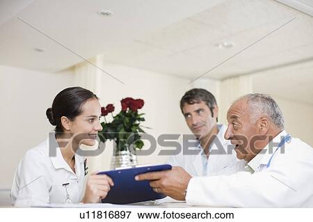 Doctors and nurse talking in hospital View Large Photo Image Stock Photo - Doctors and nurse talking in hospital. Fotosearch