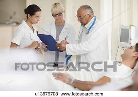 Doctors and nurse with hospital patient View Large Photo Image Stock Photo - Doctors and nurse with hospital patient. Fotosearch