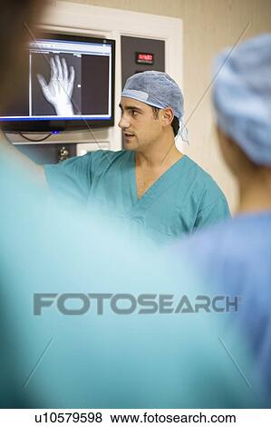 Doctors examining x-ray of hand View Large Photo Image Stock Photo - Doctors examining x-ray of hand. Fotosearch