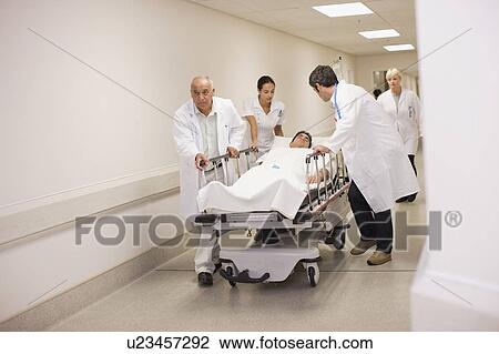 Doctors rushing patient down hallway View Large Photo Image Stock Image - Doctors rushing patient down hallway. Fotosearch