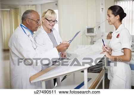 Doctors with nurse in hospital room View Large Photo Image Stock Image - Doctors with nurse in hospital room. Fotosearch