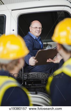 Stock Photo - Driver handing clipboard to workers. Fotosearch
