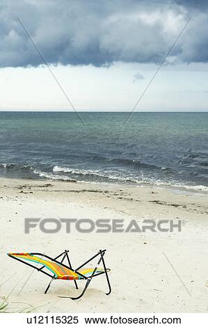 Stock Photography - Empty lawn chair on beach. Fotosearch