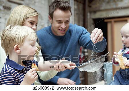 Stock Image - Family baking together in kitchen. Fotosearch