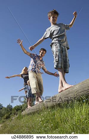 Family balancing on log outdoors View Large Photo Image Stock Photography - Family balancing on log outdoors. Fotosearch