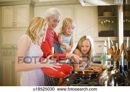 Family cooking together in kitchen View Large Photo Image Stock Image - Family cooking together in kitchen. Fotosearch