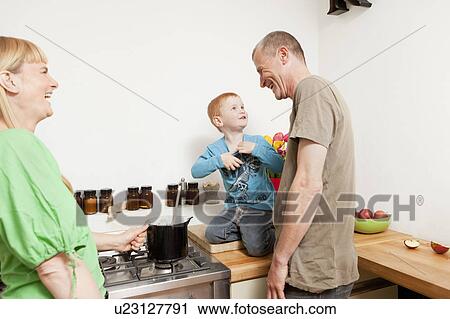 Stock Image - Family cooking together in kitchen. Fotosearch