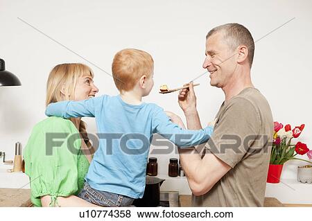 Family cooking together in kitchen View Large Photo Image Stock Photo - Family cooking together in kitchen. Fotosearch