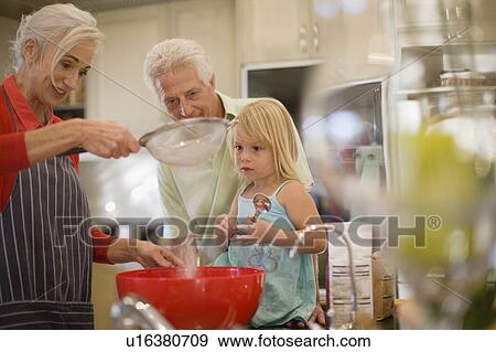 Stock Photo - Family cooking together in kitchen. Fotosearch
