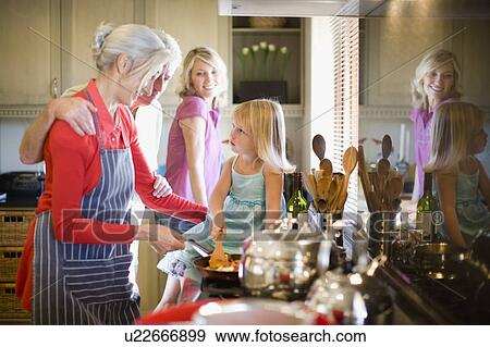 Family cooking together in kitchen View Large Photo Image Stock Photo - Family cooking together in kitchen. Fotosearch