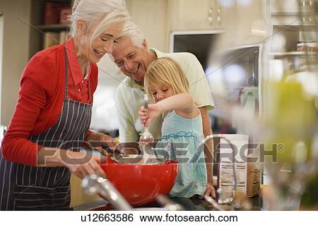 Family cooking together in kitchen View Large Photo Image Stock Photograph - Family cooking together in kitchen. Fotosearch