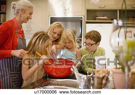 Family cooking together in kitchen View Large Photo Image Stock Photograph - Family cooking together in kitchen. Fotosearch